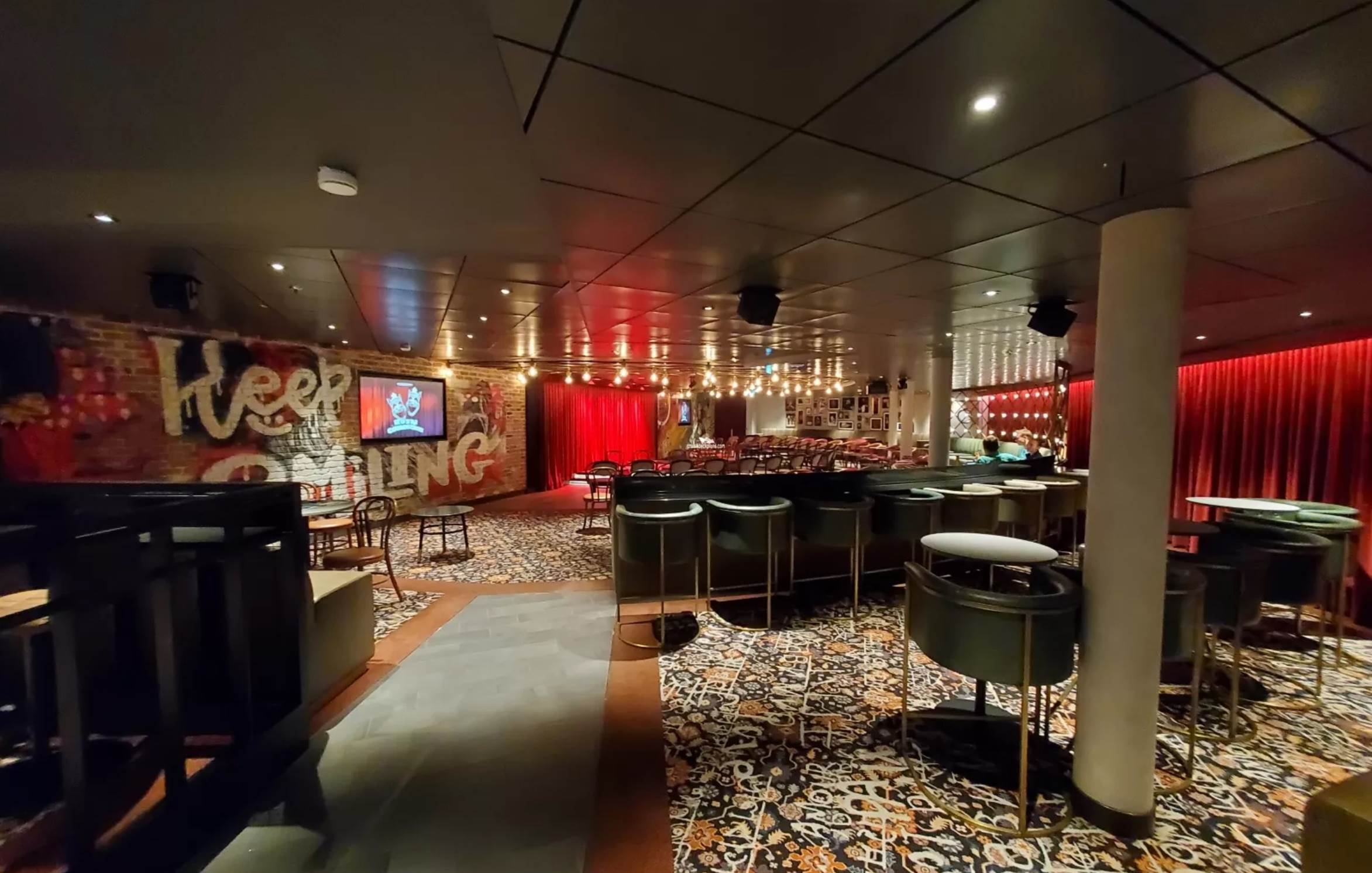 A room with a bar and chairs

Description automatically generated