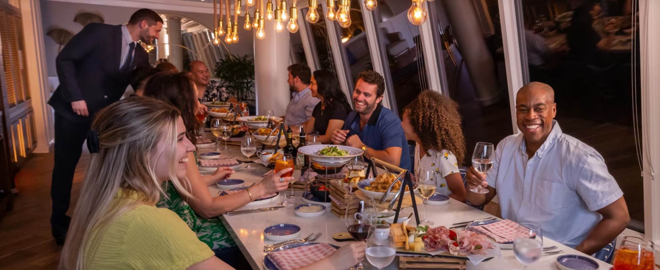 A group of people sitting at a table with food

Description automatically generated