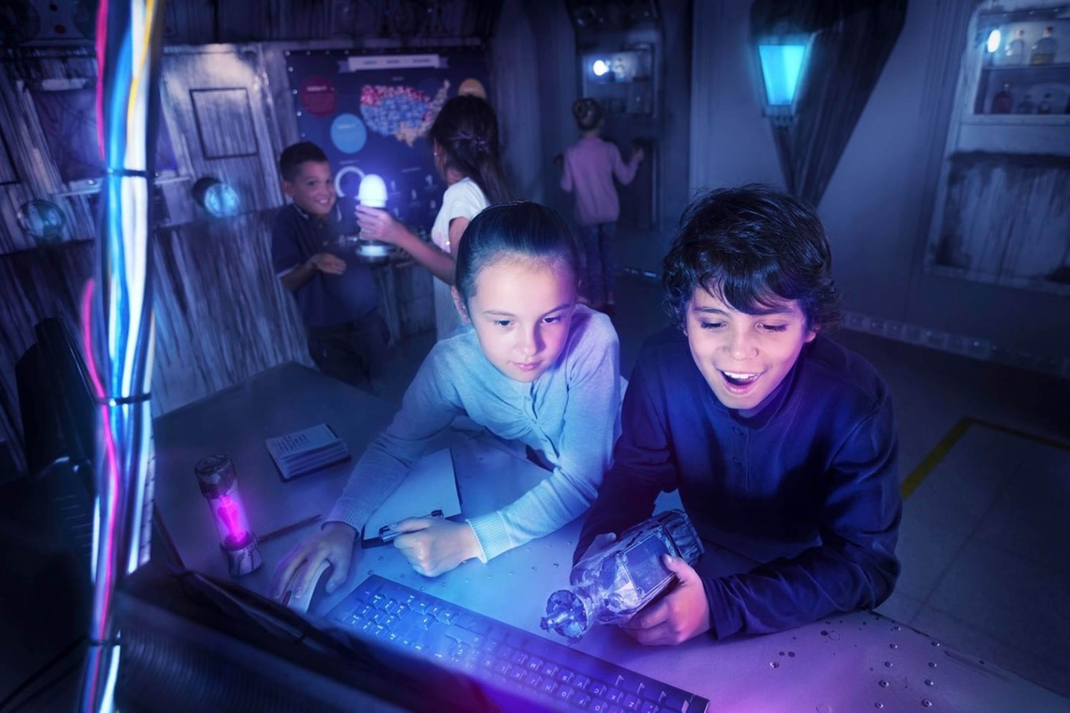 A group of kids looking at a computer

Description automatically generated