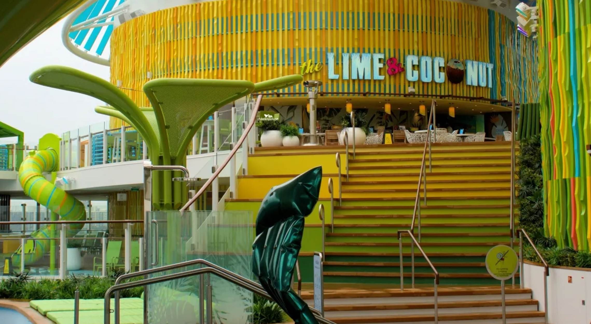 A yellow and green stairs with a building in the background

Description automatically generated