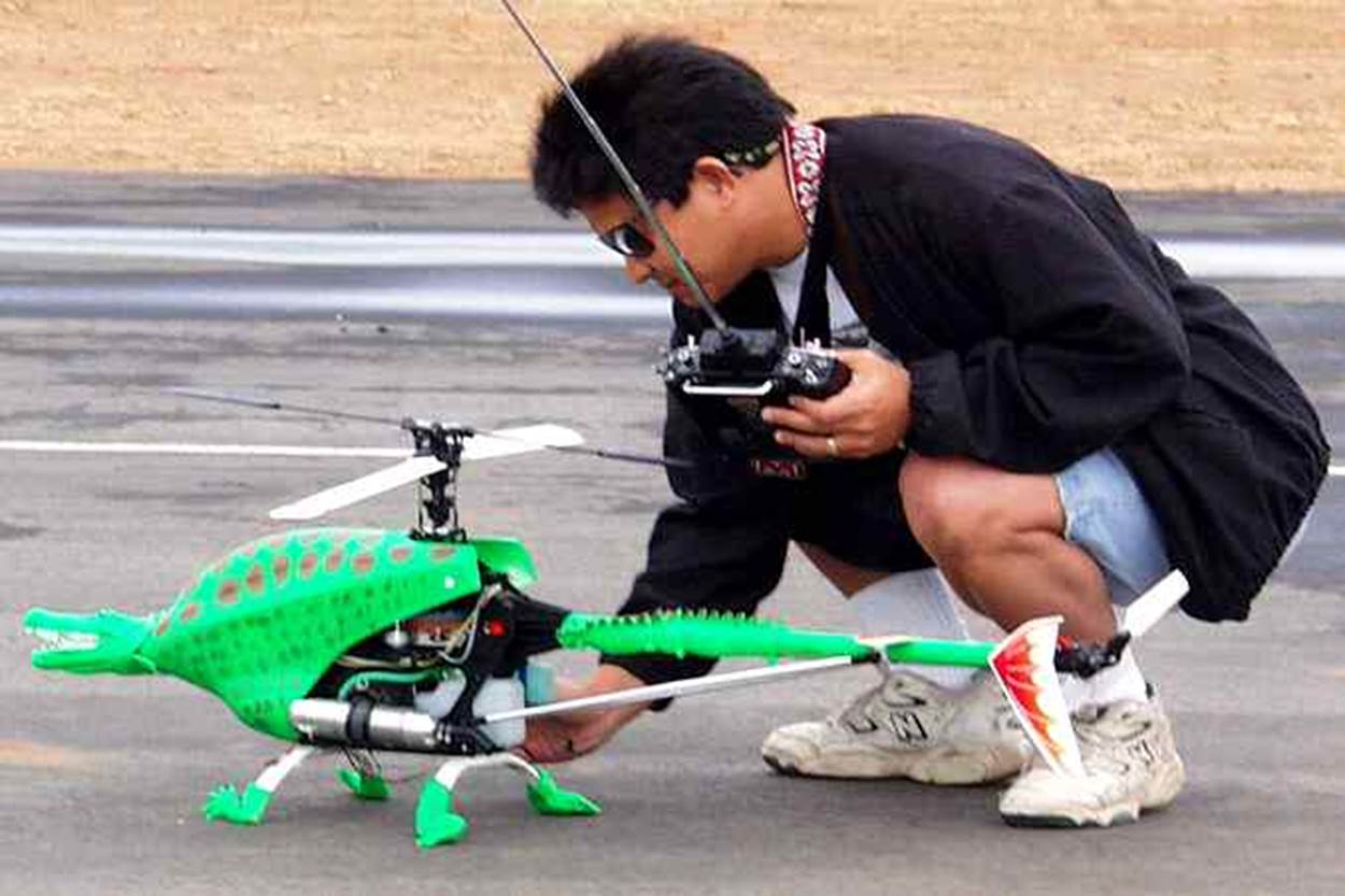 A person holding a remote control helicopter
Description automatically generated