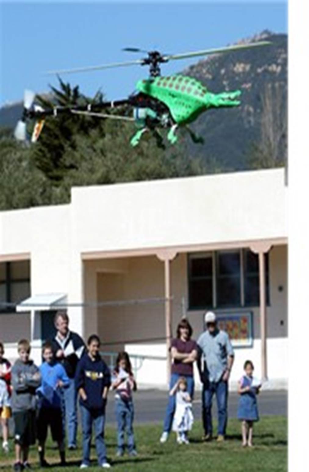 A helicopter flying over a group of people
Description automatically generated